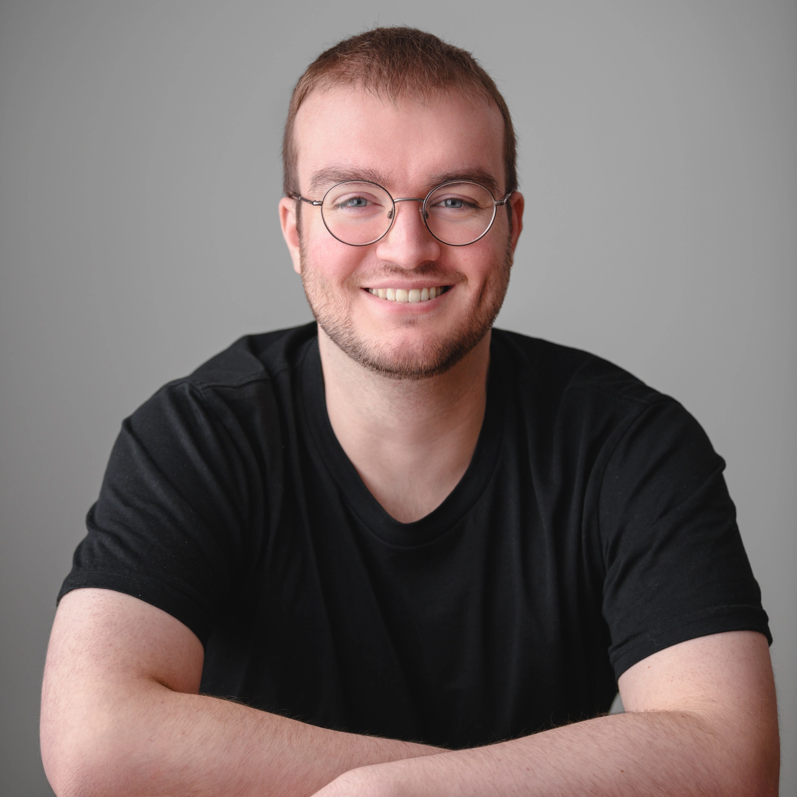 Professional headshot of George Henry (actor) against a grey background